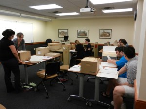 Students in the Archival Practice and Organizational Histories course meeting in the Evans Room of Special Collections.