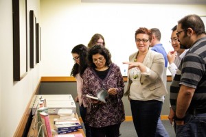 Attendees and panelists mingle, discuss, and view some of Mena's works at last months event.    Additional photos of the event can be viewed here. (Photo courtesy of Mauricio Lazo, University of Houston Libraries.)